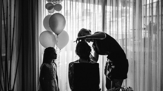 niña con globos mira como maquillan a la novia